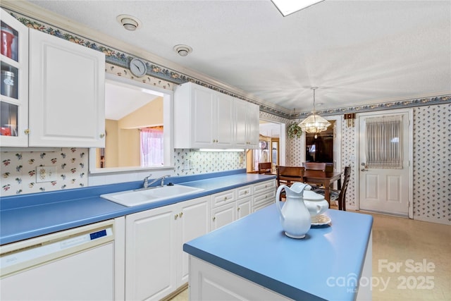 kitchen with decorative light fixtures, white cabinetry, dishwasher, sink, and a notable chandelier