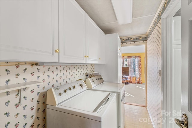 clothes washing area with cabinets and independent washer and dryer