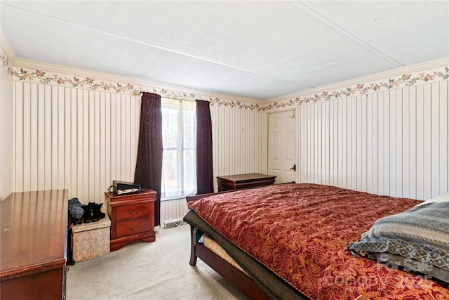 bedroom with ornamental molding and light colored carpet