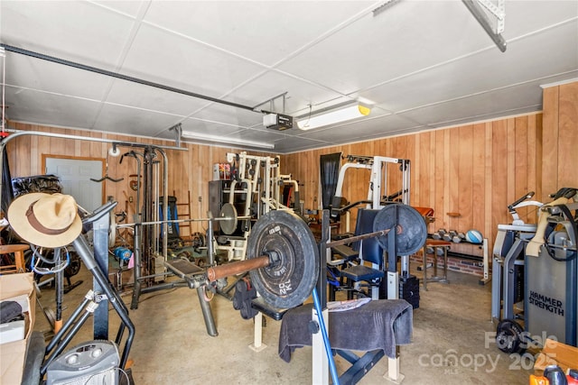 garage with a garage door opener and wood walls