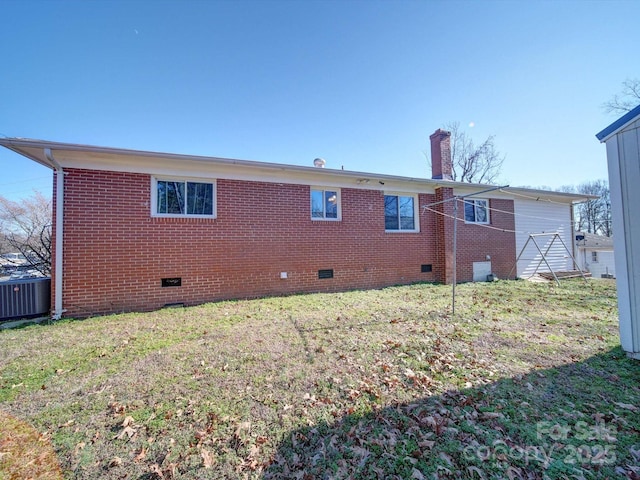 back of house featuring a lawn and central air condition unit