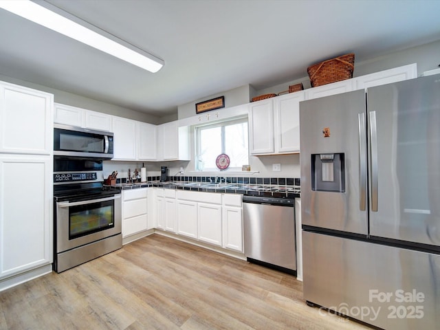 kitchen featuring white cabinetry, appliances with stainless steel finishes, and light hardwood / wood-style flooring