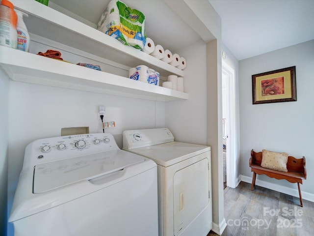 washroom with washer and clothes dryer and light wood-type flooring