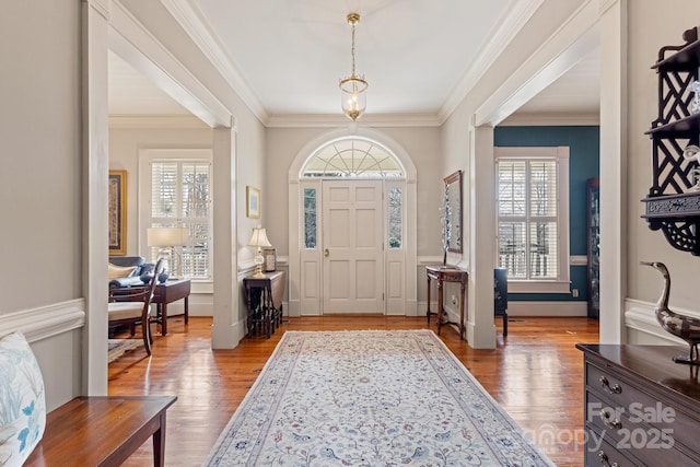 foyer with crown molding, light hardwood / wood-style flooring, and a wealth of natural light