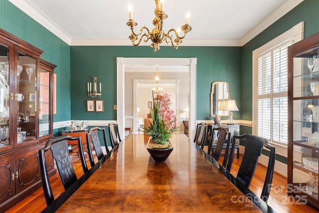 dining area with an inviting chandelier, hardwood / wood-style flooring, and crown molding