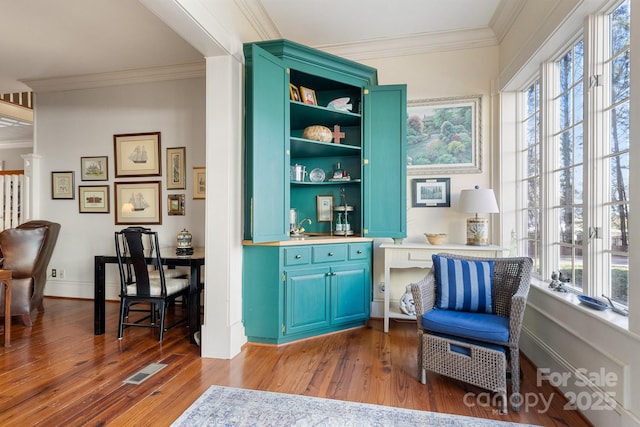 sitting room featuring crown molding, plenty of natural light, and dark hardwood / wood-style floors
