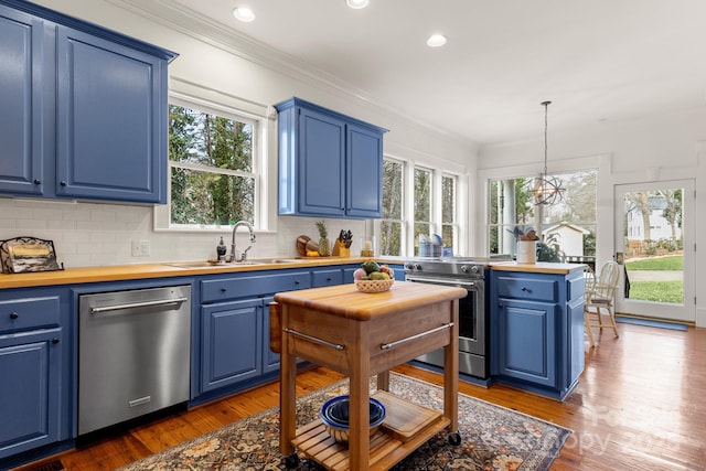 kitchen with sink, stainless steel appliances, hanging light fixtures, and blue cabinetry