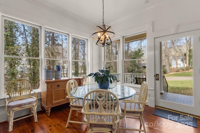 sunroom / solarium featuring a notable chandelier