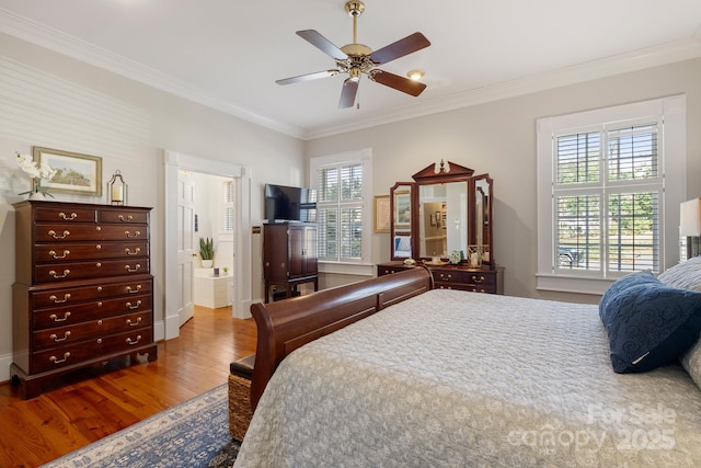 bedroom with multiple windows, wood-type flooring, and crown molding