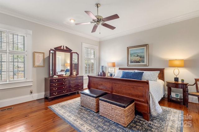bedroom with multiple windows, crown molding, hardwood / wood-style flooring, and ceiling fan