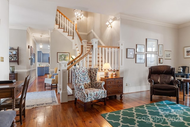 living room with crown molding, hardwood / wood-style flooring, and an inviting chandelier