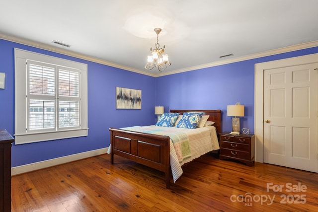 bedroom featuring a notable chandelier, crown molding, and dark wood-type flooring