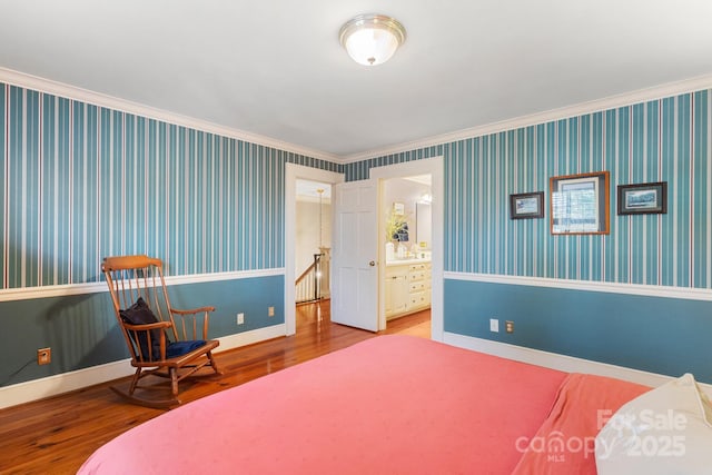 bedroom with hardwood / wood-style flooring, ensuite bathroom, and crown molding