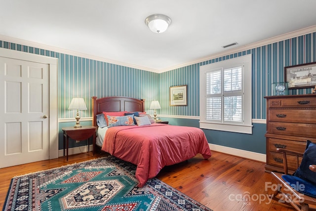 bedroom with hardwood / wood-style flooring and crown molding