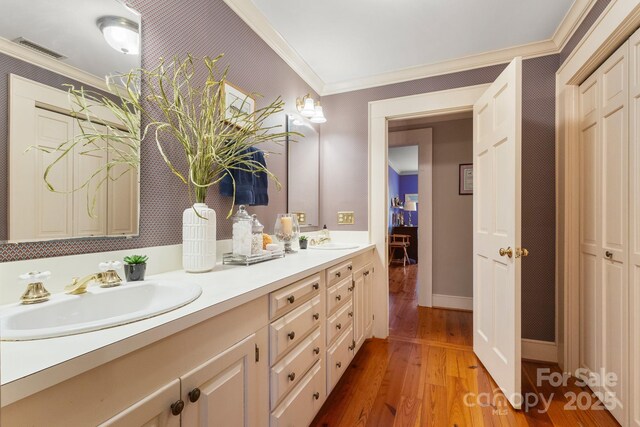 bathroom featuring vanity, ornamental molding, and hardwood / wood-style floors