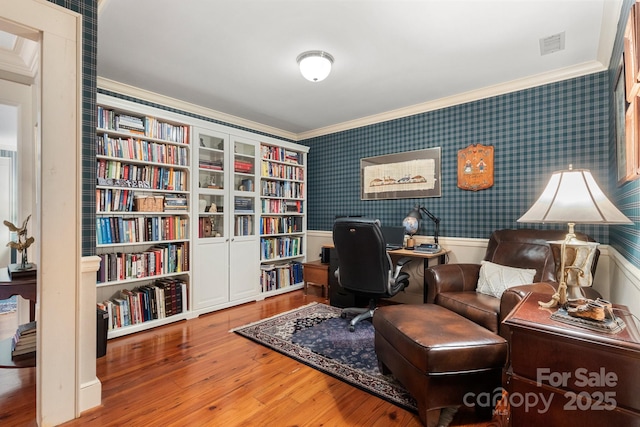 sitting room with ornamental molding and wood-type flooring