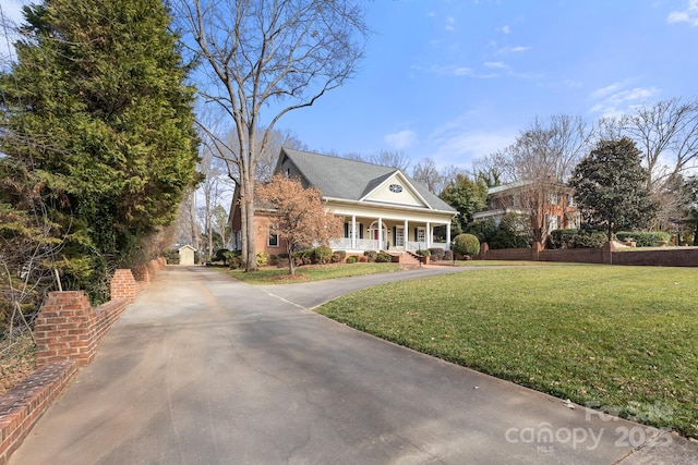 neoclassical home featuring a porch and a front yard