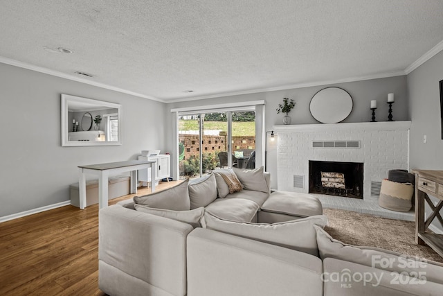 living room featuring a fireplace, ornamental molding, hardwood / wood-style floors, and a textured ceiling