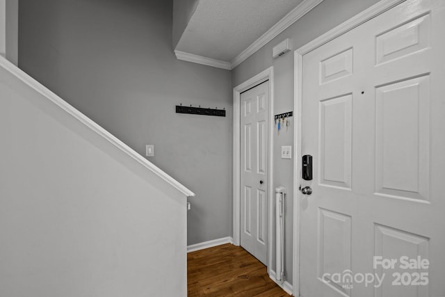 entrance foyer with crown molding, dark hardwood / wood-style flooring, and a textured ceiling