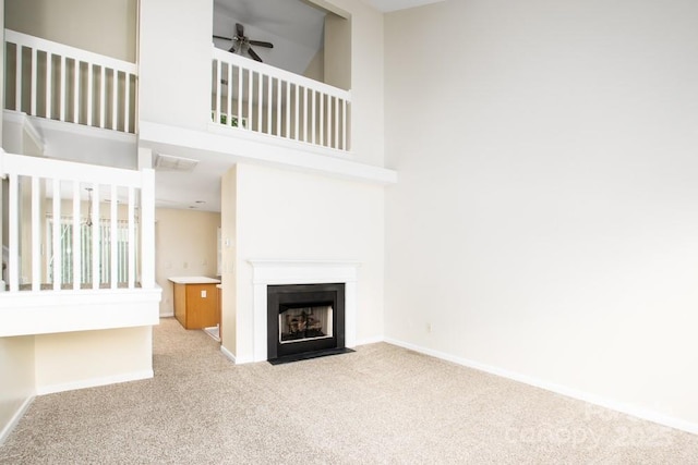 1748 Pergola Pl, Charlotte, NC 28213 - unfurnished living room with a high ceiling, carpet floors, a ceiling fan, baseboards, and a fireplace with flush hearth