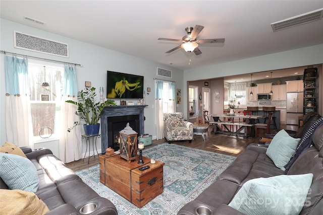 living room with ceiling fan, a healthy amount of sunlight, and dark hardwood / wood-style floors