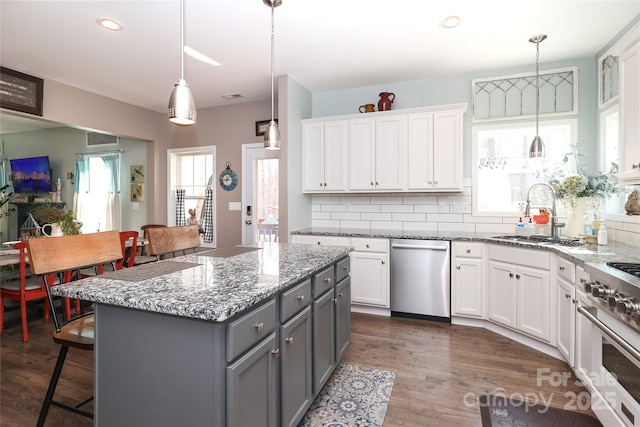 kitchen with a center island, appliances with stainless steel finishes, gray cabinets, pendant lighting, and white cabinets