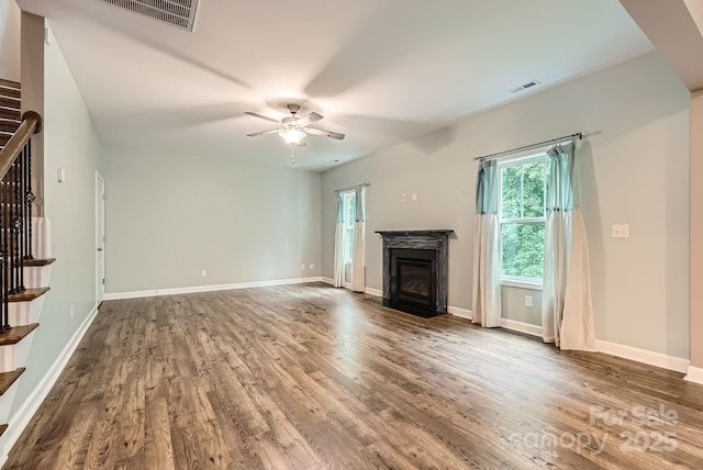 2864 Park Ridge Blvd, Rock Hill, SC 29732 - unfurnished living room featuring wood finished floors, ceiling fan, a fireplace with flush hearth, and stairway