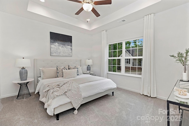 bedroom featuring a raised ceiling, carpet, and ceiling fan