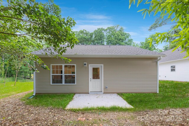 rear view of property featuring a patio area and a lawn