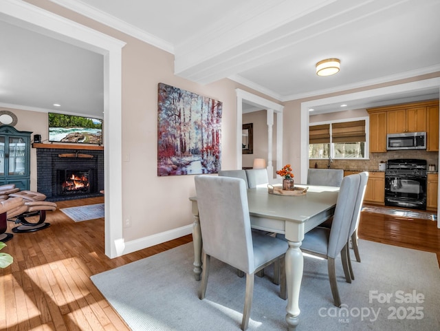 dining space with ornamental molding, light wood-type flooring, and plenty of natural light