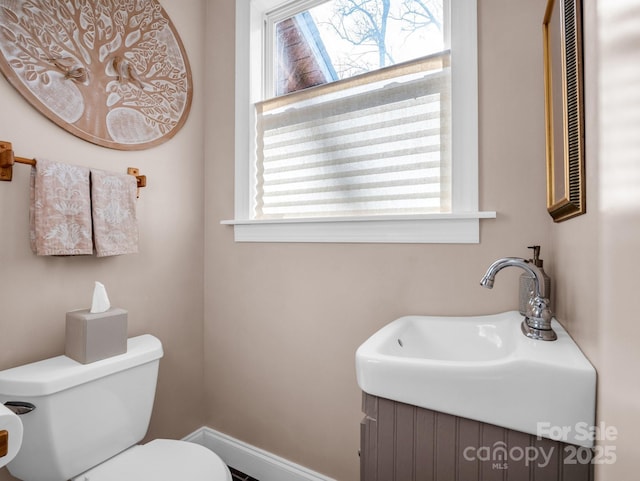 bathroom featuring a healthy amount of sunlight, toilet, and sink