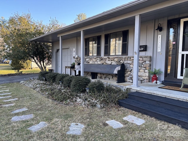 doorway to property featuring a porch and a garage