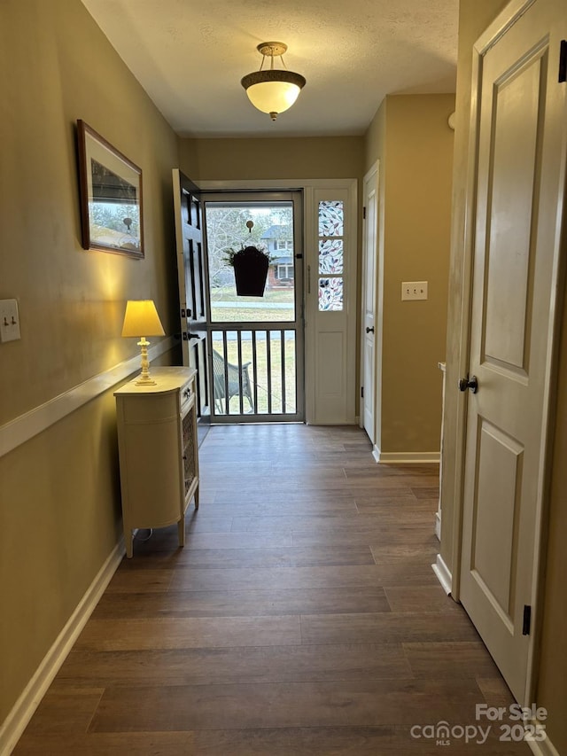 doorway featuring dark hardwood / wood-style floors and a textured ceiling