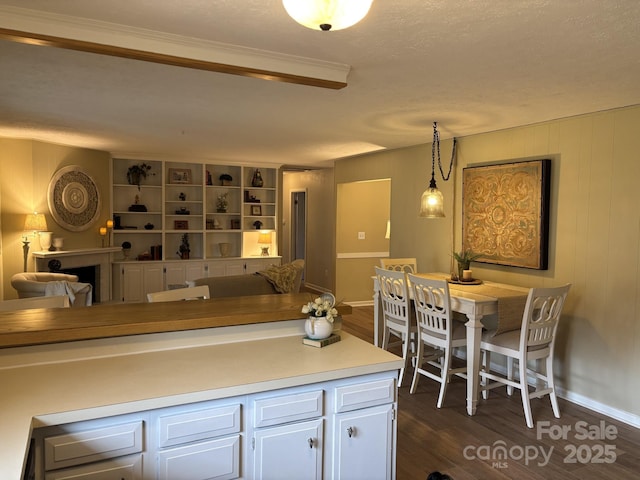 kitchen featuring dark wood-type flooring, hanging light fixtures, and white cabinets