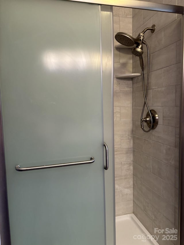 bathroom with a shower with door