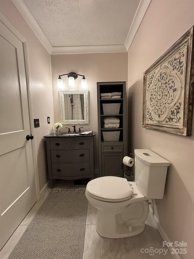 bathroom with crown molding, vanity, a textured ceiling, and toilet