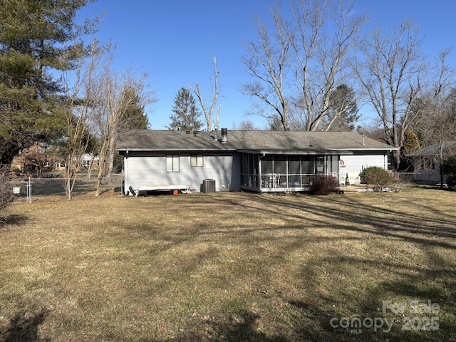 rear view of house with central AC unit, a lawn, and a sunroom