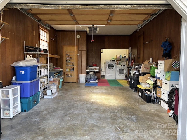 garage with washing machine and dryer and wooden walls