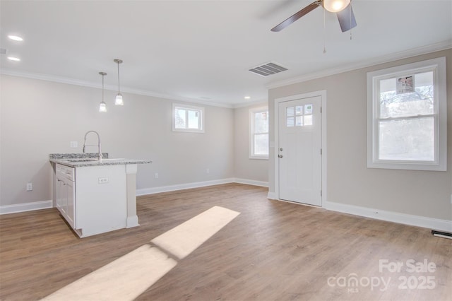 kitchen featuring ornamental molding, decorative light fixtures, and sink