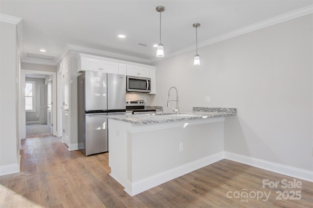 kitchen with sink, white cabinetry, kitchen peninsula, pendant lighting, and stainless steel appliances