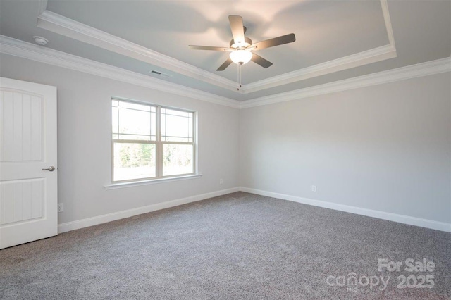 carpeted empty room featuring crown molding, ceiling fan, and a raised ceiling