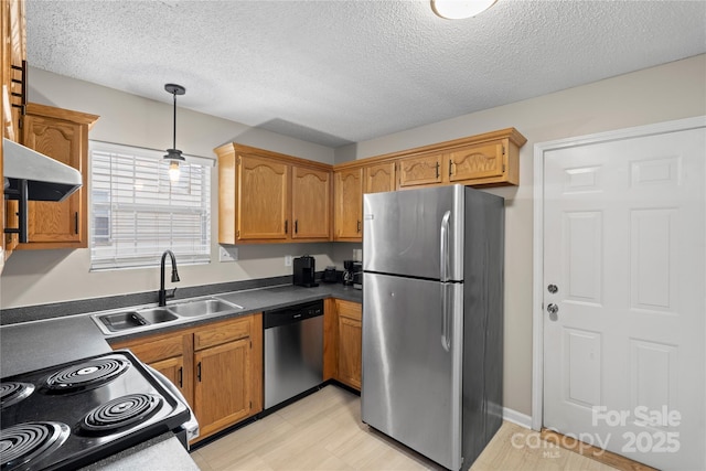 kitchen featuring extractor fan, sink, hanging light fixtures, a textured ceiling, and appliances with stainless steel finishes