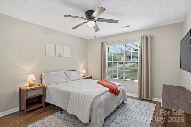 bedroom with wood-type flooring, ceiling fan, and a textured ceiling