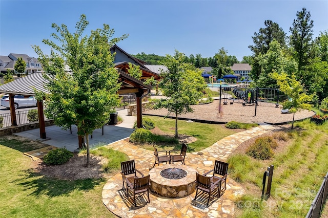 view of home's community with a patio area, a gazebo, a yard, a playground, and a fire pit