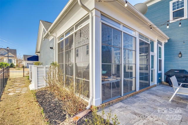 view of home's exterior with a sunroom and a patio area