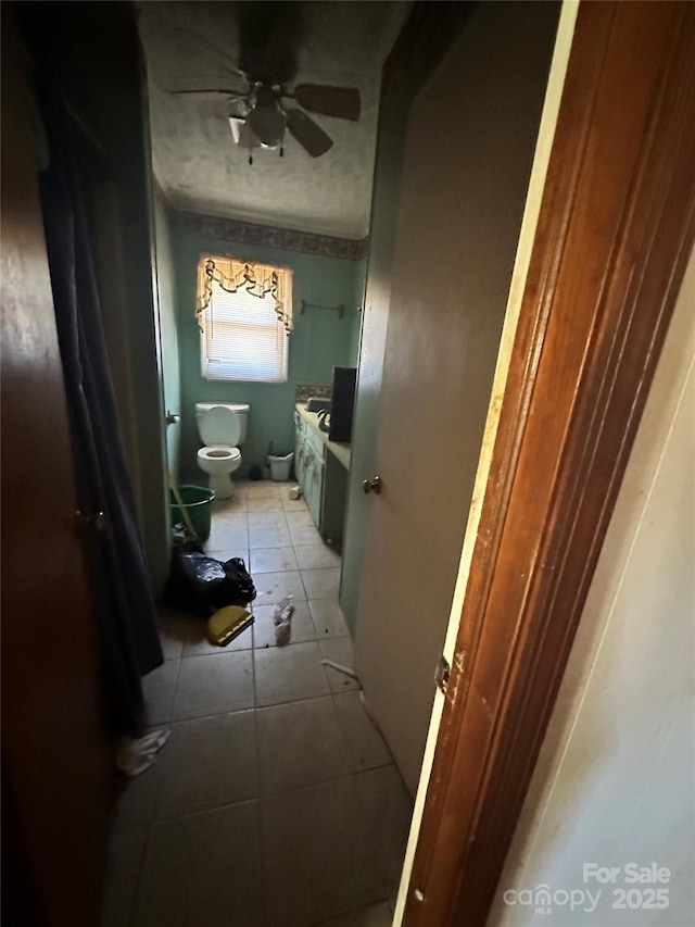 bathroom with ceiling fan, toilet, and tile patterned flooring