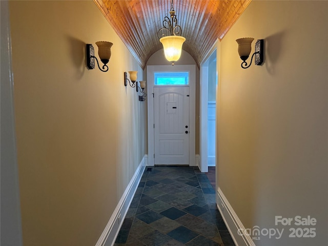 doorway with wood ceiling and vaulted ceiling