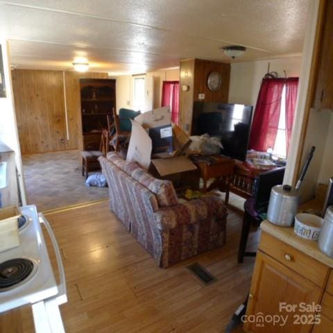 living room with wooden walls and light hardwood / wood-style floors