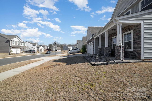 view of yard with an attached garage and a residential view