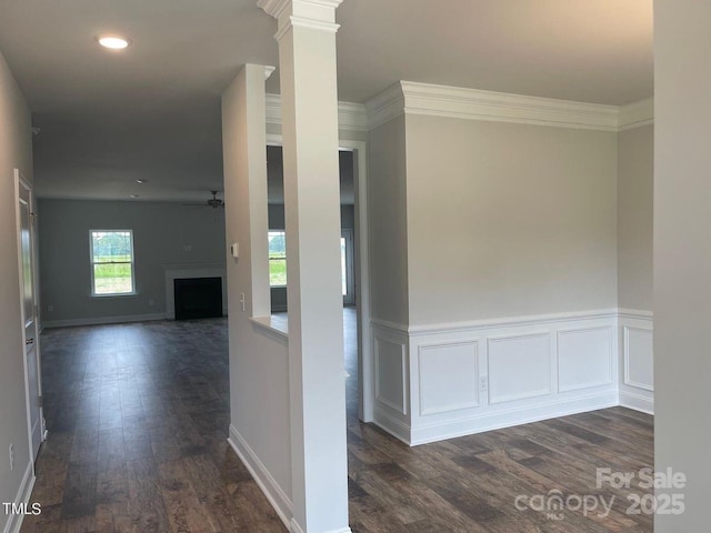 hallway with decorative columns, ornamental molding, and dark hardwood / wood-style floors